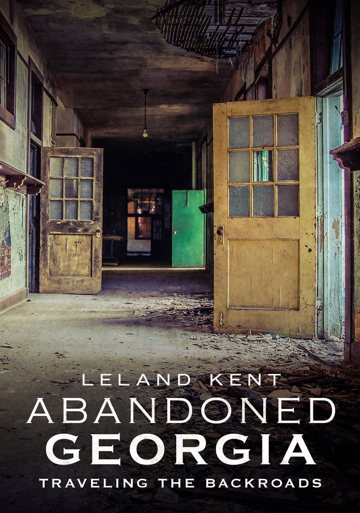 The cover image features a dilapidated, abandoned school building with broken windows and a rustic, weathered exterior. The title 'Abandoned Georgia: Traveling the Backroads' is prominently displayed at the top, along with the author's name, Leland Kent.