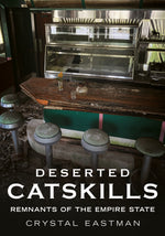 Book cover for 'Deserted Catskills: Remnants of the Empire State' by Crystal Eastman, featuring a dark, abandoned diner interior with a wooden counter, green-painted front, and metal display cases, with the title in large white text at the bottom.