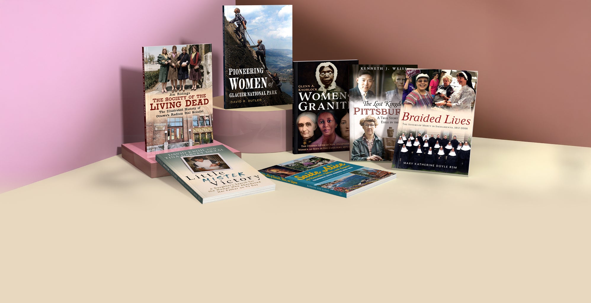 Collection of books celebrating Women's History Month published by America Through Time® on a table with a pink wall background