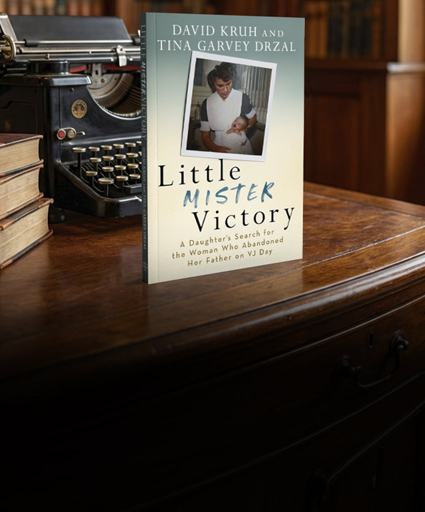 Book titled 'Little Mister Victory' by David Kruh and Tina Garvey Drzal on a wooden surface with an old typewriter.
