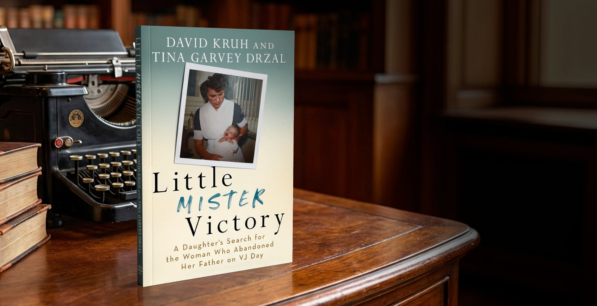 Book titled 'Little Mister Victory' by David Kruh and Tina Garvey Drzal on a wooden table with a typewriter in the background.