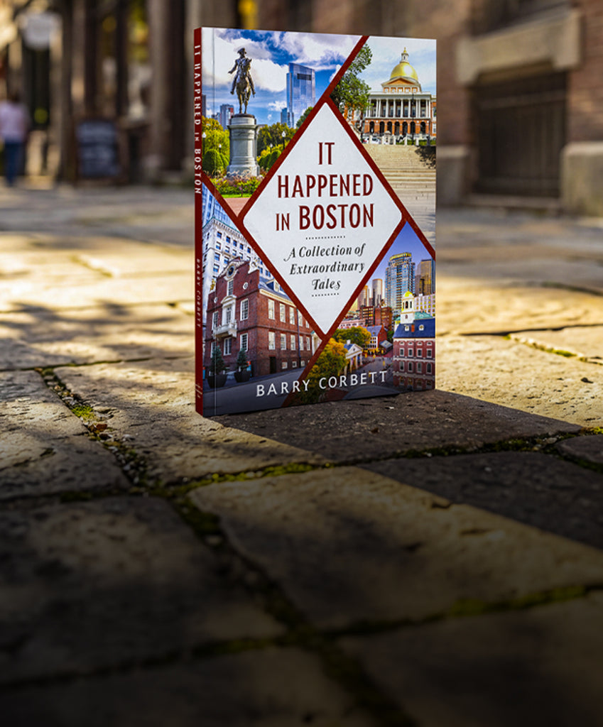 Book titled 'It Happened in Boston' by Barry Corbett on a stone pavement with a cityscape background.